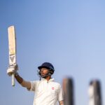 a man holding a cricket bat in his hand